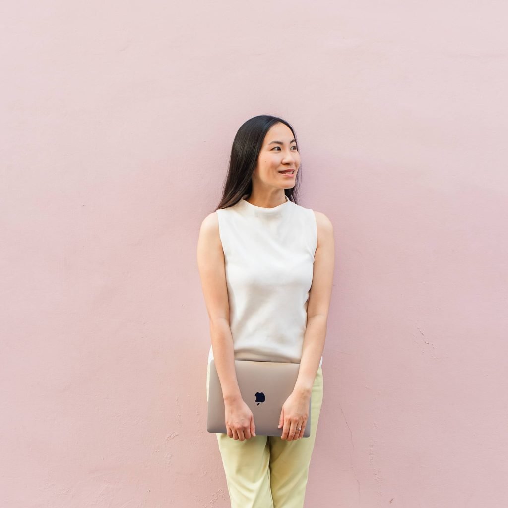 Founder Leanne Wong standing in front of a pink wall, smiling