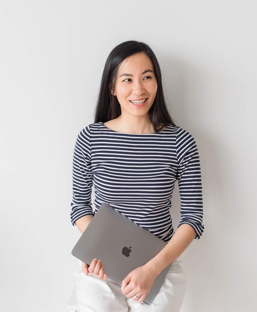 Founder Leanne Wong holding her laptop, smiling to the side
