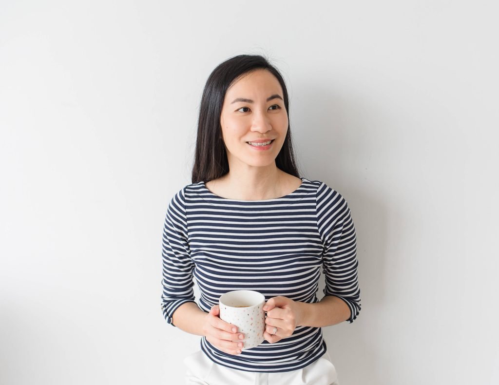 Founder Leanne Wong holding a mug, smiling to the side